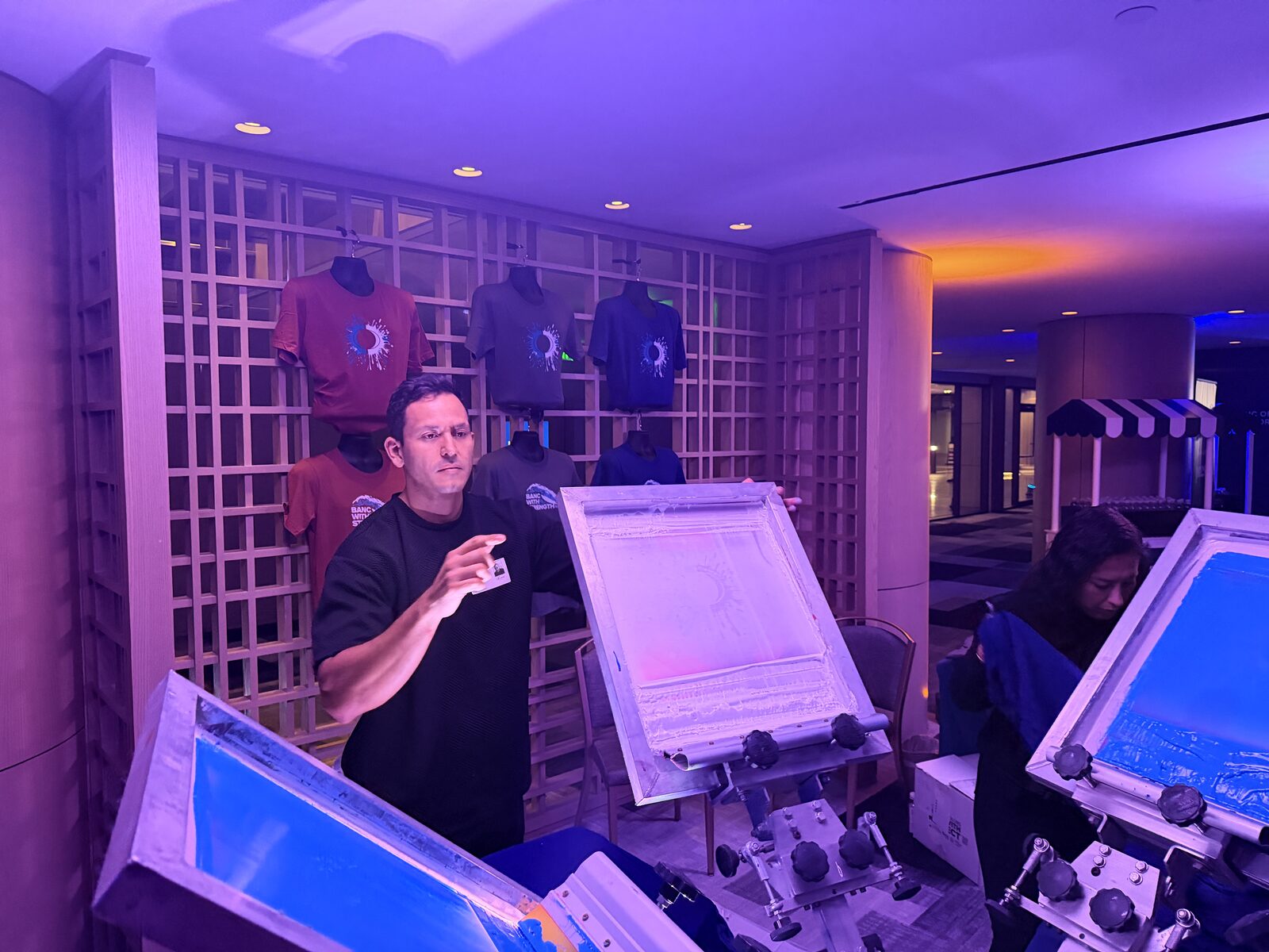 Glowing live printing booth with heat-press stations running after dark at an event